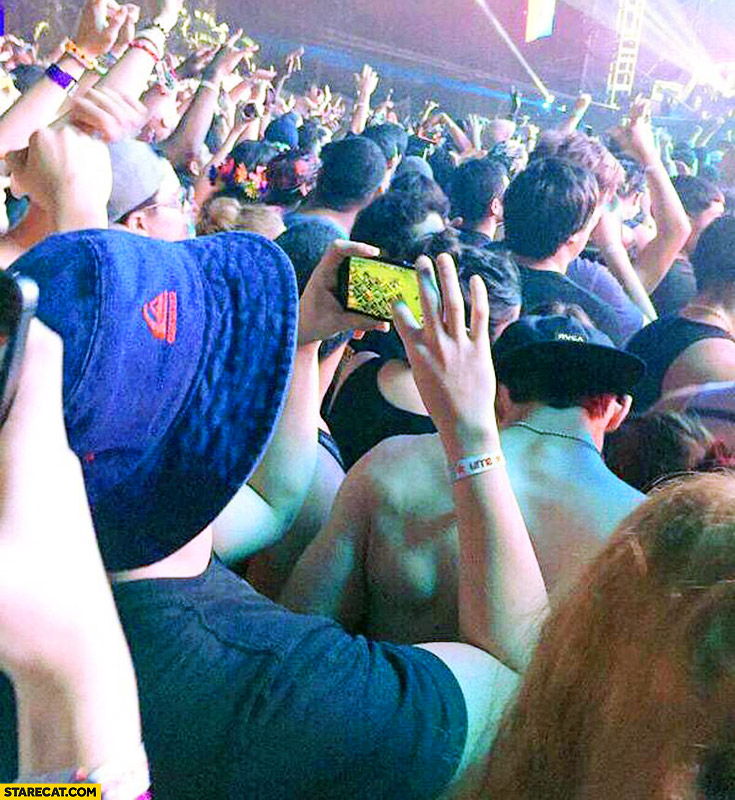 Guy playing Clash of Clans on a concert